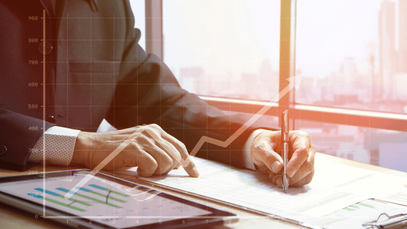 Business persons hands looking at report with an over lay of a chart