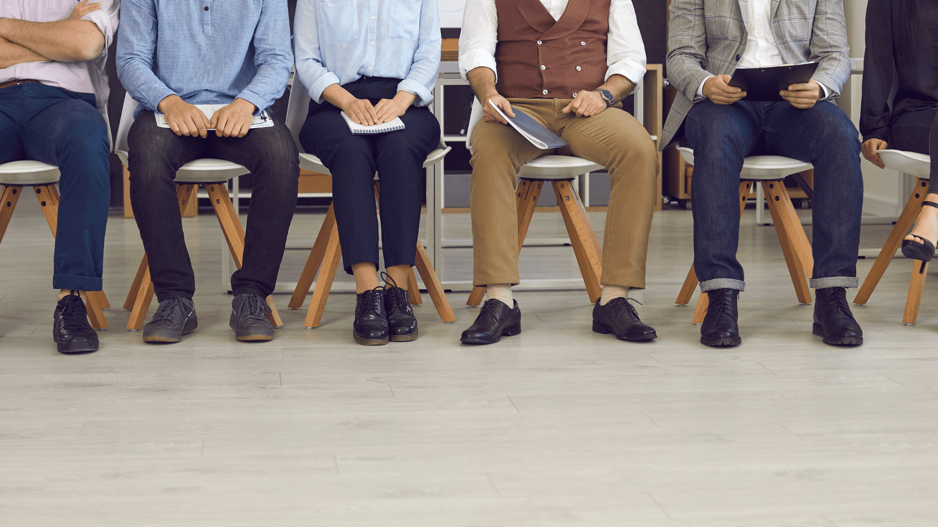 multiple men and women shown from the waist down sitting in a waiting room