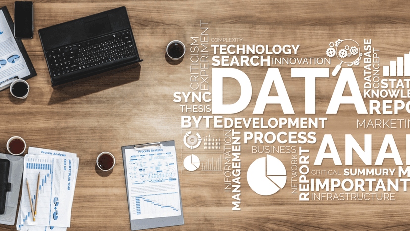overhead view of conference table with laptops, reports, and coffee. Super imposed word cloud with finance terms and phrases
