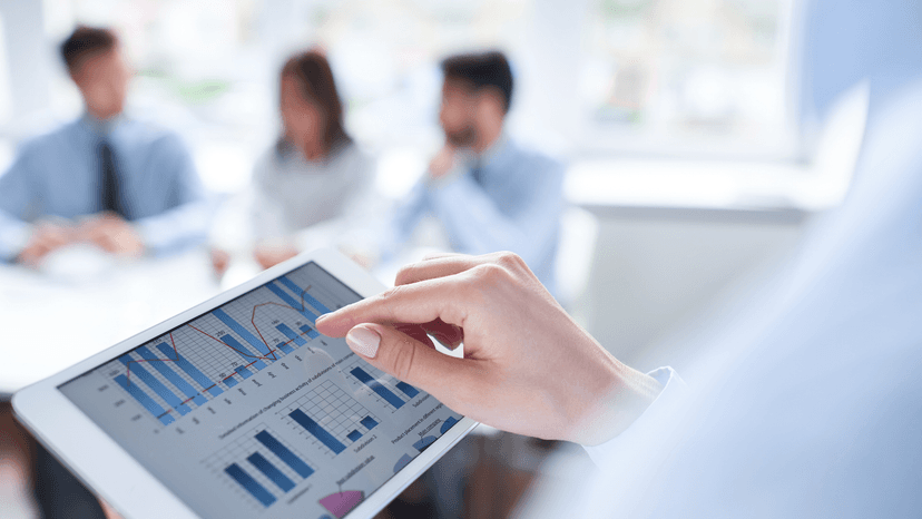 ipad with digital dashboard, meeting in the background