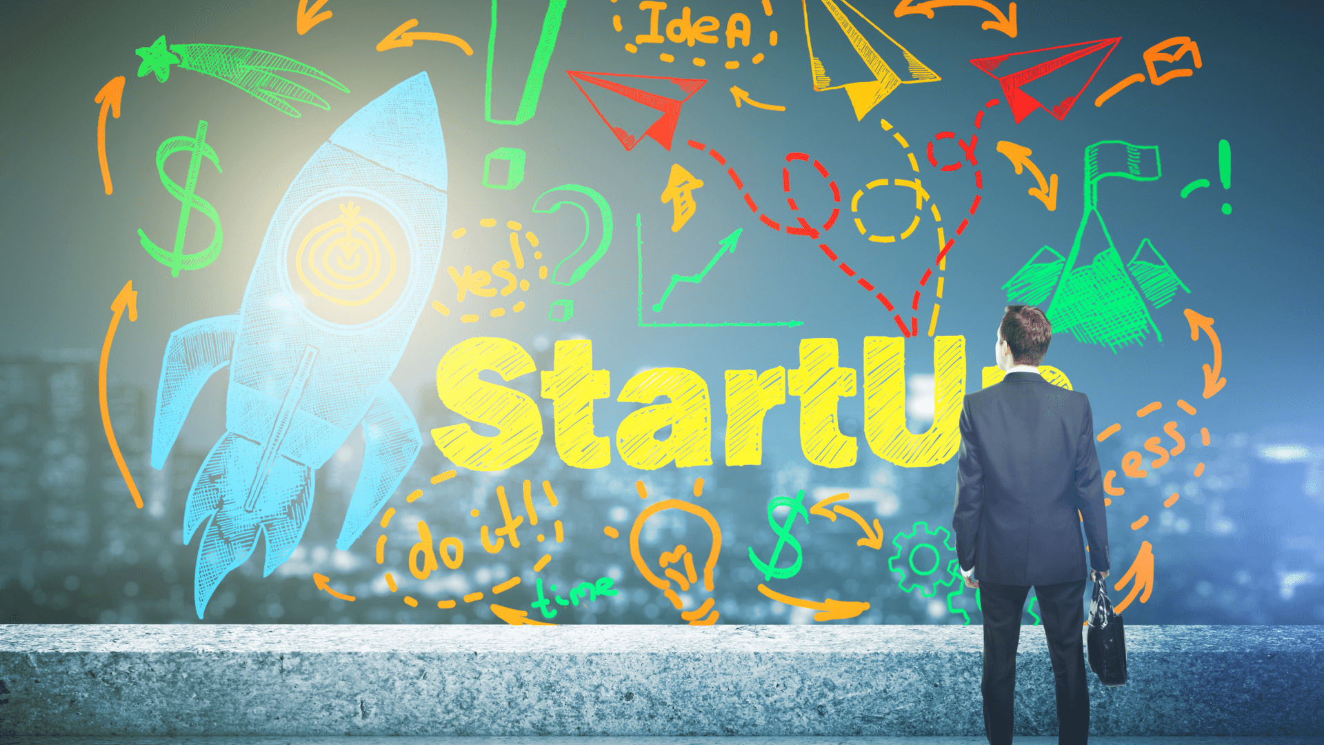 man standing in front of colorful painting with the word StartUp