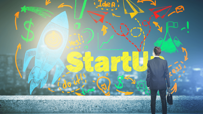 man standing in front of colorful painting with the word StartUp
