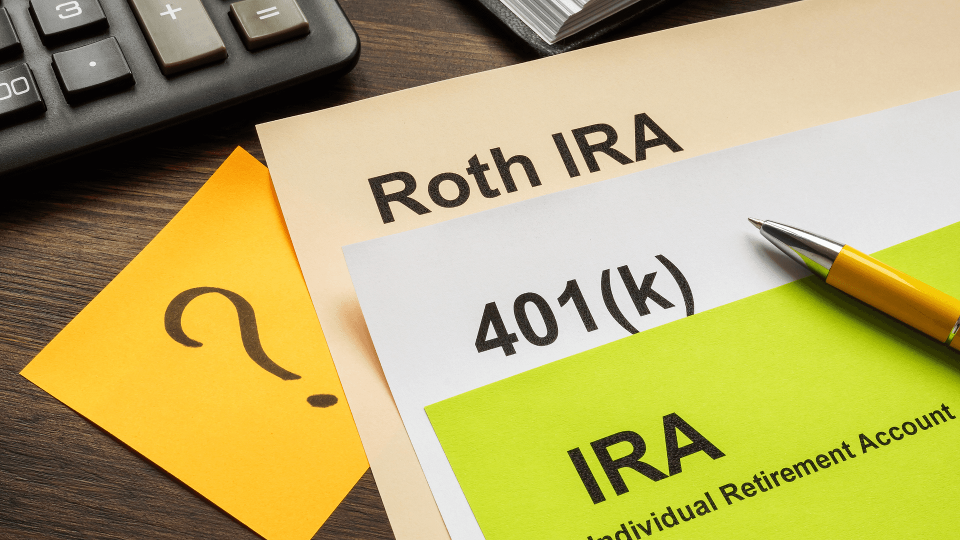document sitting on a desk: Roth IRA, 401(k), and IRA, with a sticky note with a ?