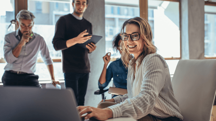 professionals smiling and collaborating in a modern tech office