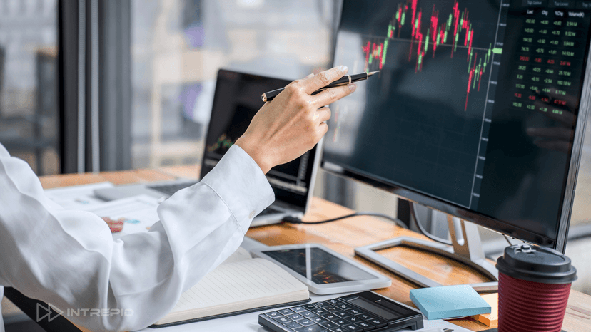 Broker reviewing financial charts on computer screen while discussing AR-backed working capital vs traditional lines of credit.